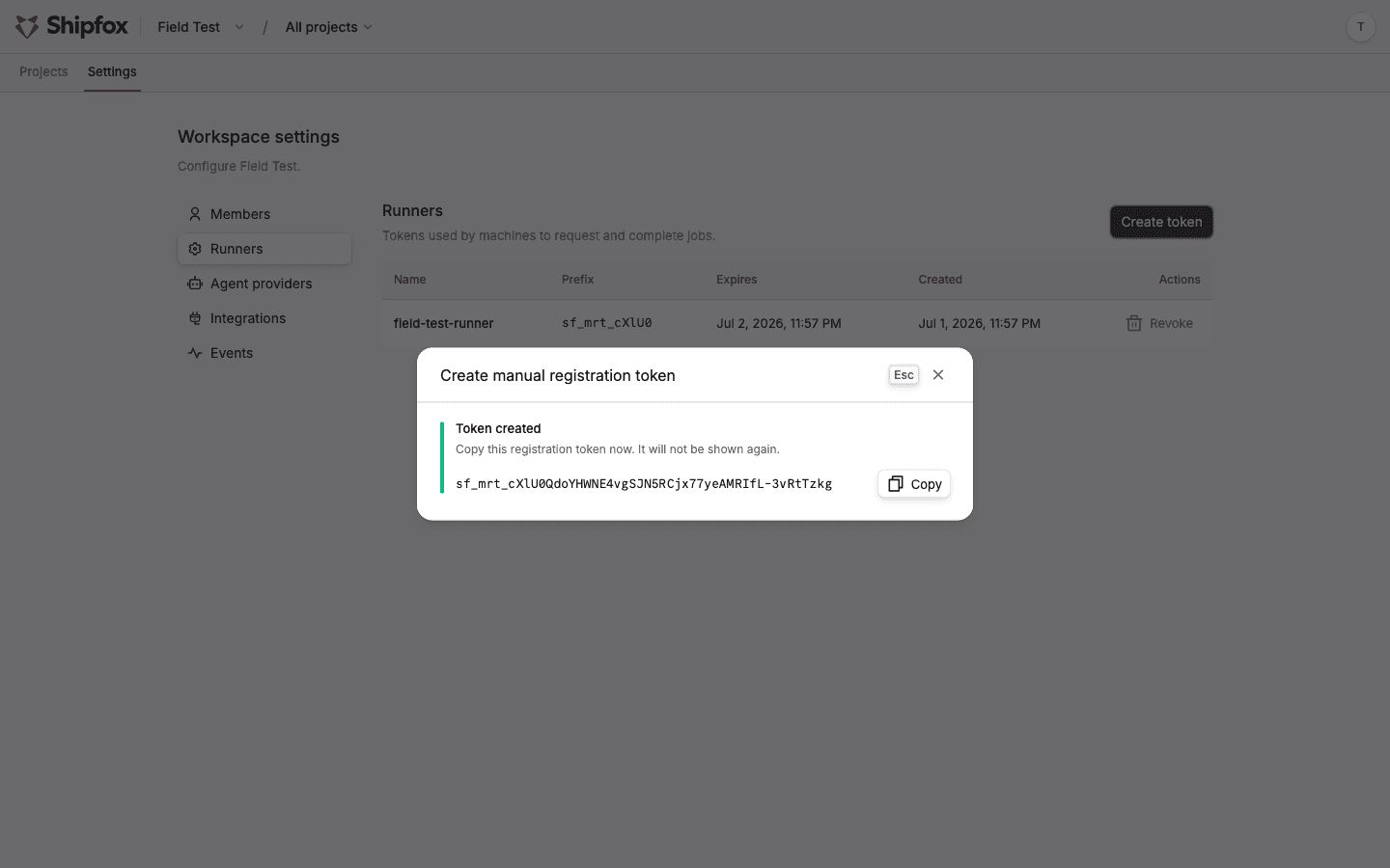 The create registration token dialog on Settings → Runners, showing the one-time token value and copy button